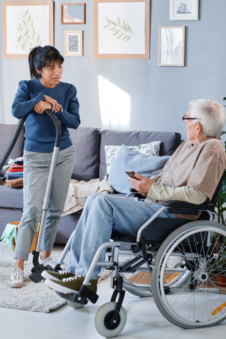 senior man talking to housemaid at home